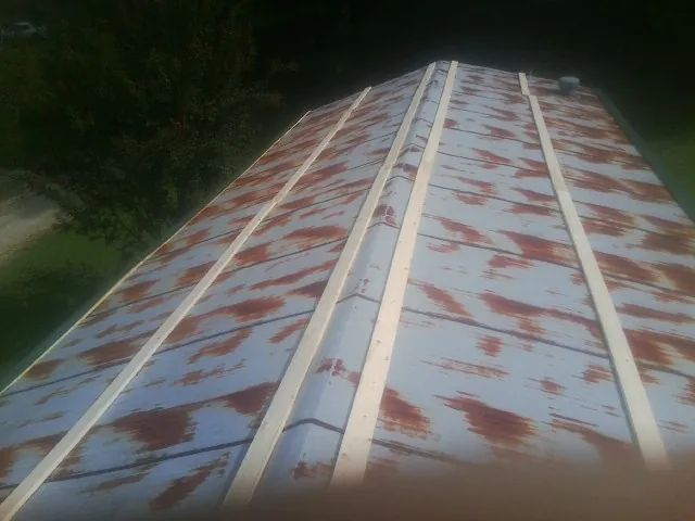 Rusted metal roof panels with new wood purlins before replacement — Storm Damage Roof Repair in Sodus Point by Roofing Brothers
