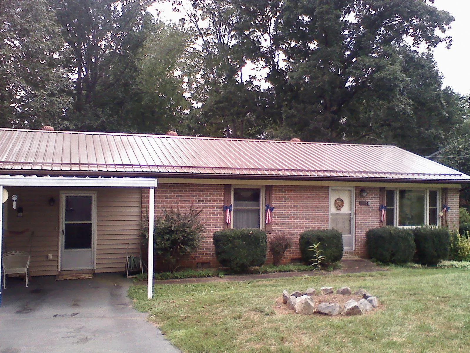 Bronze metal roof and carport on a brick ranch home in Sodus Point
